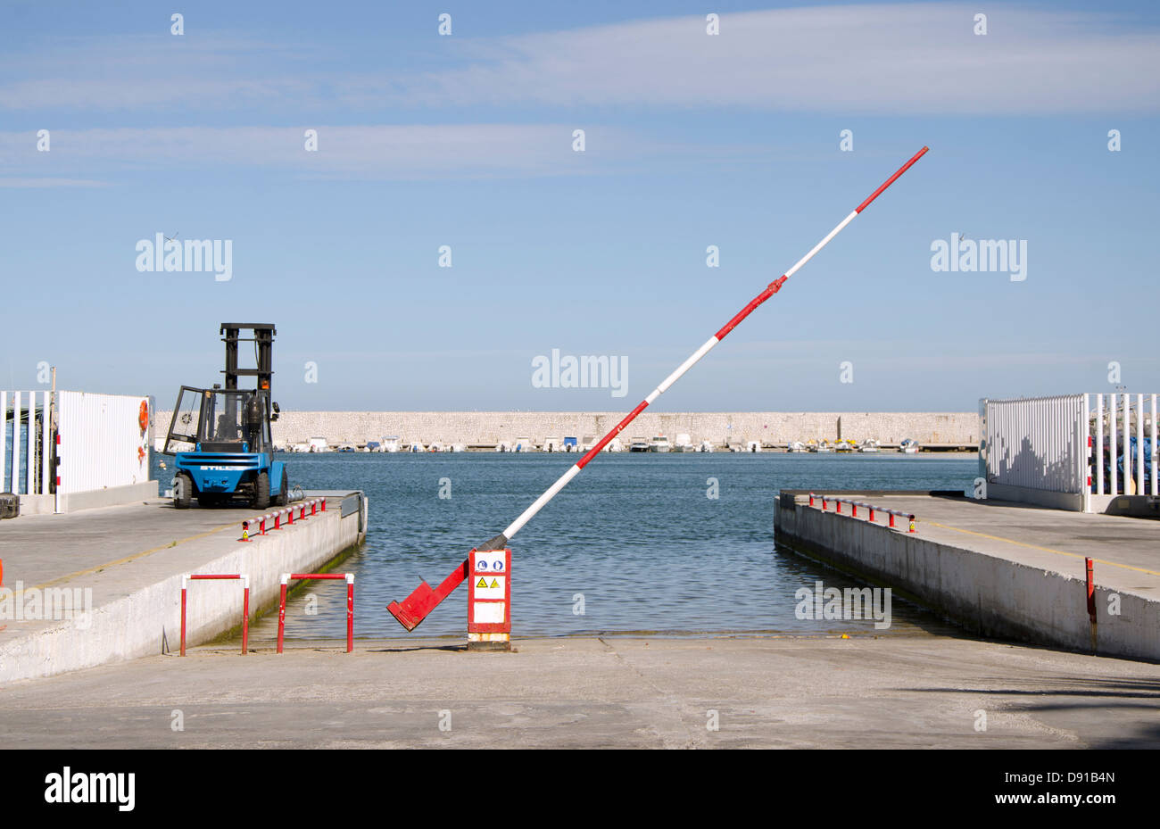 Rampe de mise à l'eau avec chariot élévateur et un passage à niveau dans le port de Fuengirola, Costa del Sol, Espagne. Banque D'Images