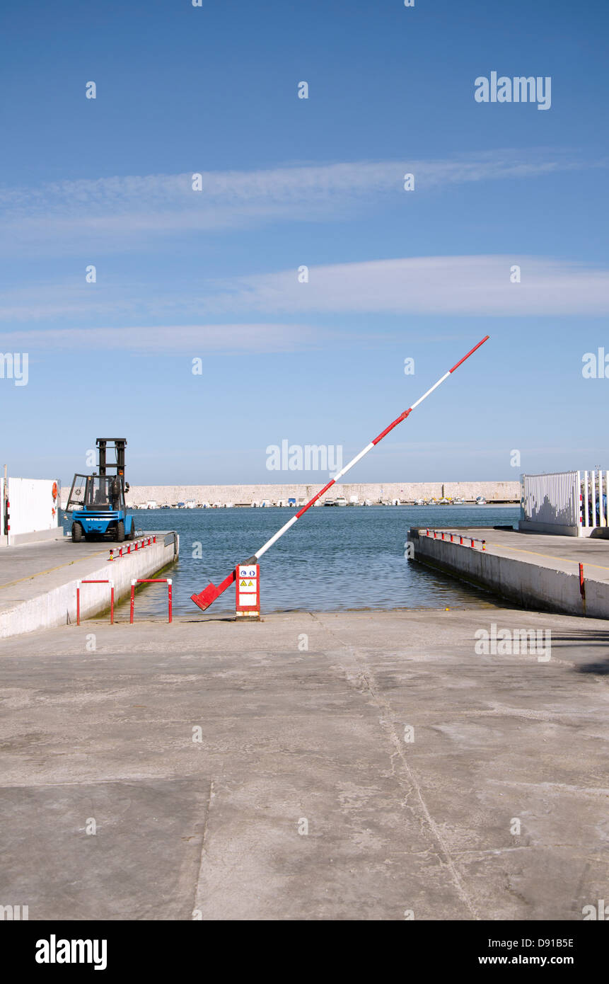 Rampe de mise à l'eau avec chariot élévateur et un passage à niveau dans le port de Fuengirola, Costa del Sol, Espagne. Banque D'Images