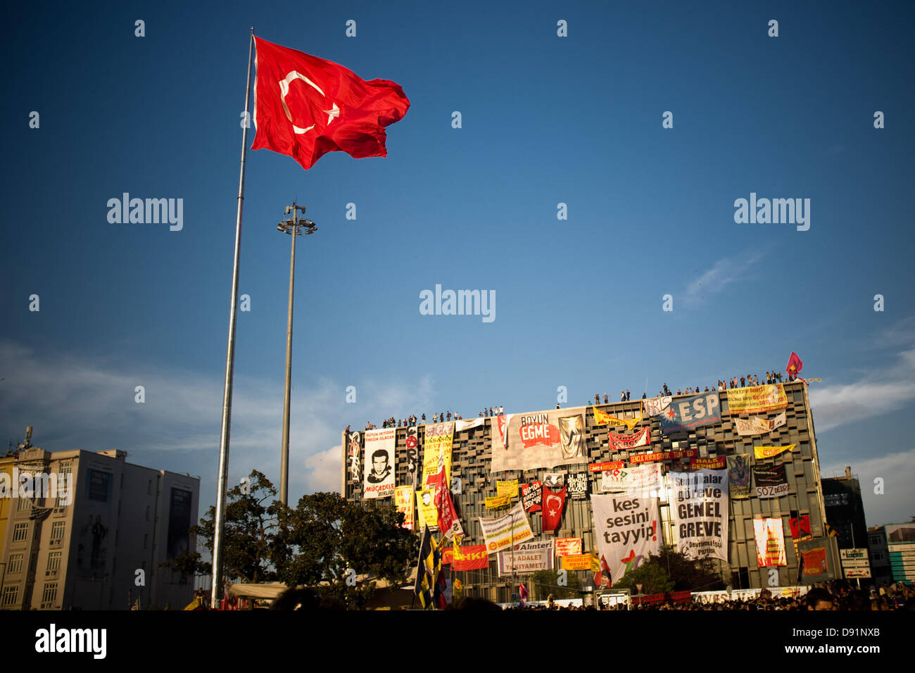 La Place Taksim, Istanbul, Turquie. 8 juin, 2013. Un immense drapeau turc vole à côté du bâtiment Centre Culturel Ataturk, occupés par des manifestants depuis le début des manifestations. Un autre jour les habitants d'Istanbul au crépuscule aller vers la Place Taksim à manifester leur protestation contre le gouvernement de M. Erdogan. Crédit : Jordi Boixareu/Alamy Live News Banque D'Images