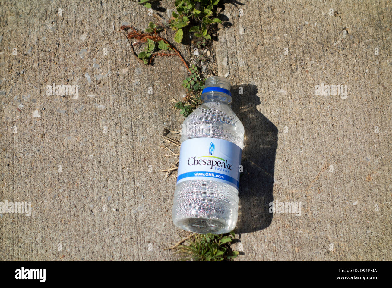 Une bouteille d'eau vide abandonné dans le stationnement près de l'exercice à des sentiers du lac Hefner, Oklahoma City, Oklahoma, USA. Banque D'Images