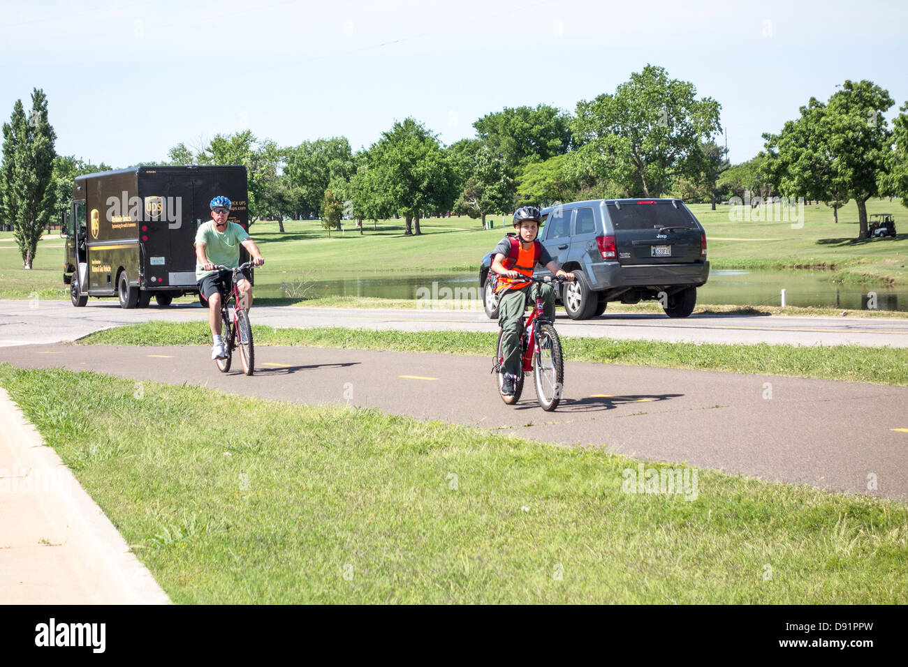Portrait d'un père et son fils faire du vélo pour faire de l'exercice et le plaisir sur le sentiers du lac Hefner à Oklahoma City, Oklahoma, USA. Banque D'Images