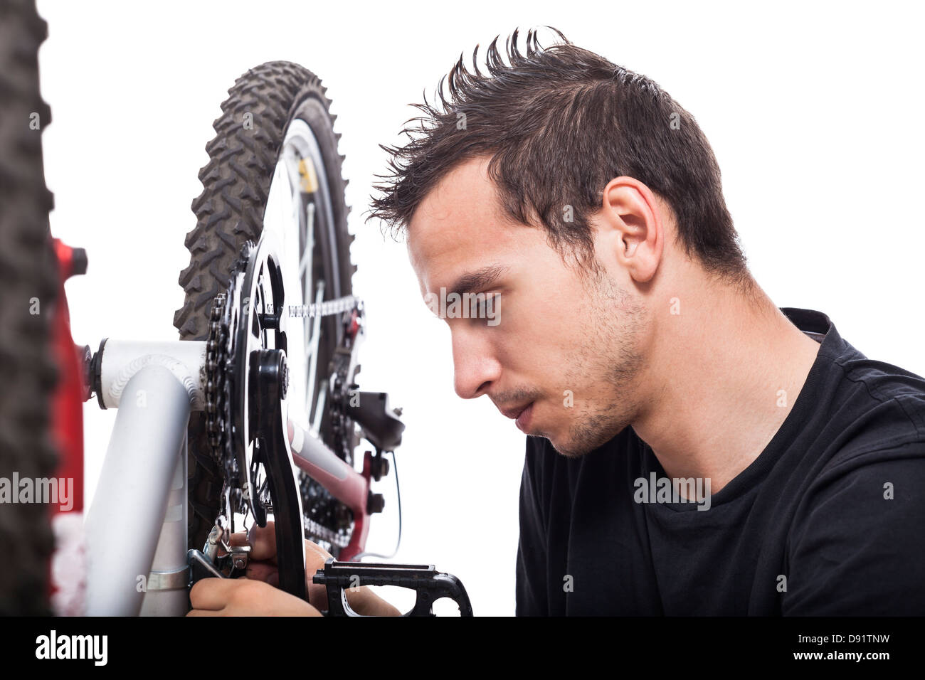 Jeune homme la réparation de vélo, isolé sur fond blanc Banque D'Images