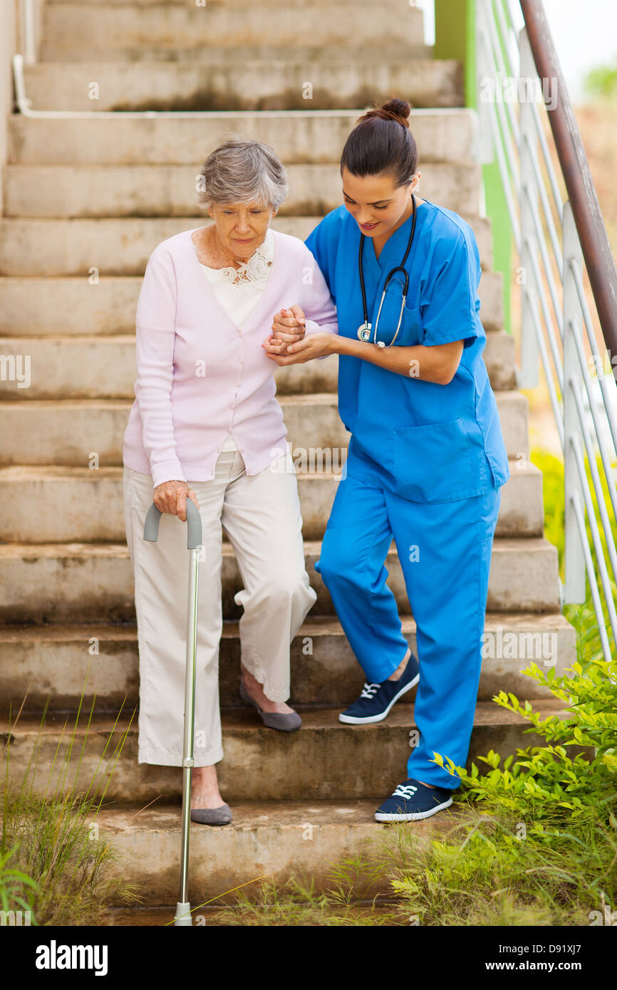 Caring nurse helping senior patient descendant des escaliers Banque D'Images