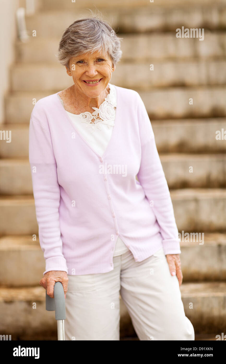 Professionnels personnes âgées dame debout par canne avec escalier Banque D'Images