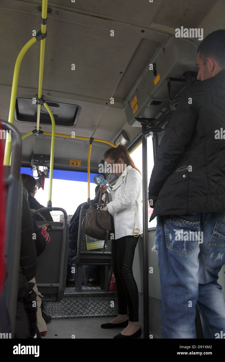 Belle jeune femme de trouver son juste dans un bus dolmus Banque D'Images