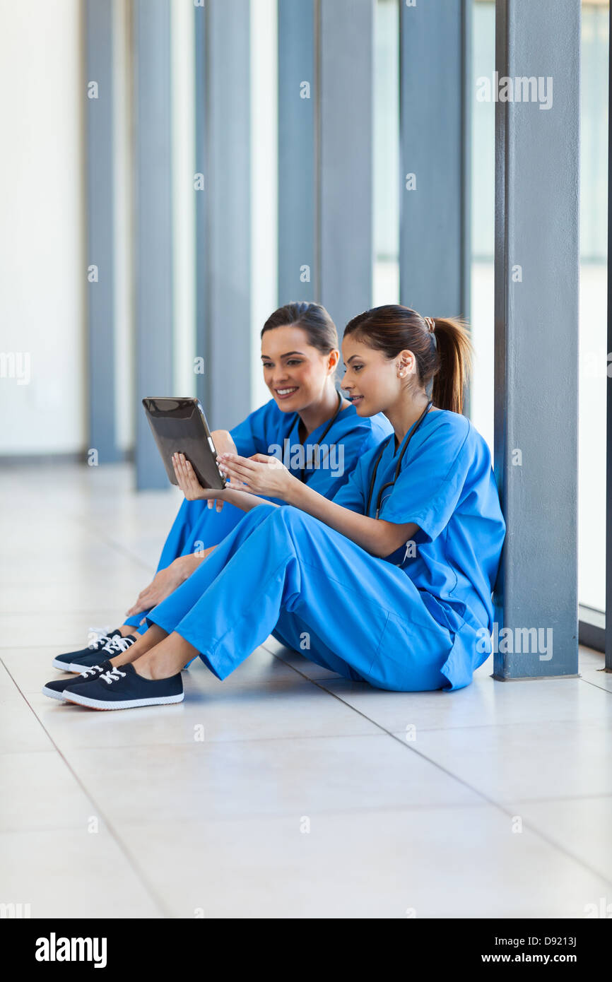 Les femmes en soins infirmiers à l'aide de l'ordinateur tablette pendant les pauses Banque D'Images