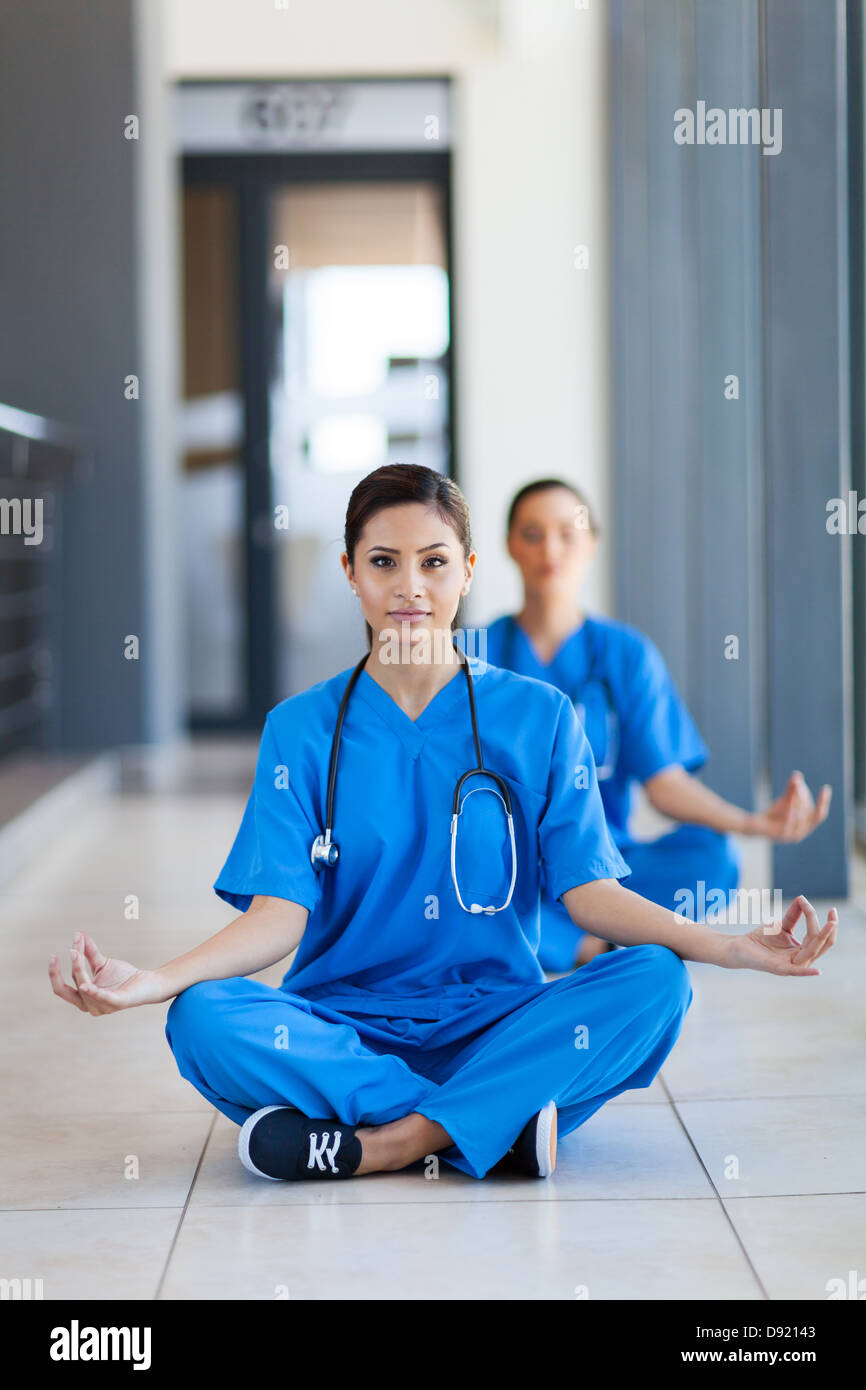 Deux jolies infirmières faisant la méditation pendant les pauses à l'hôpital Banque D'Images