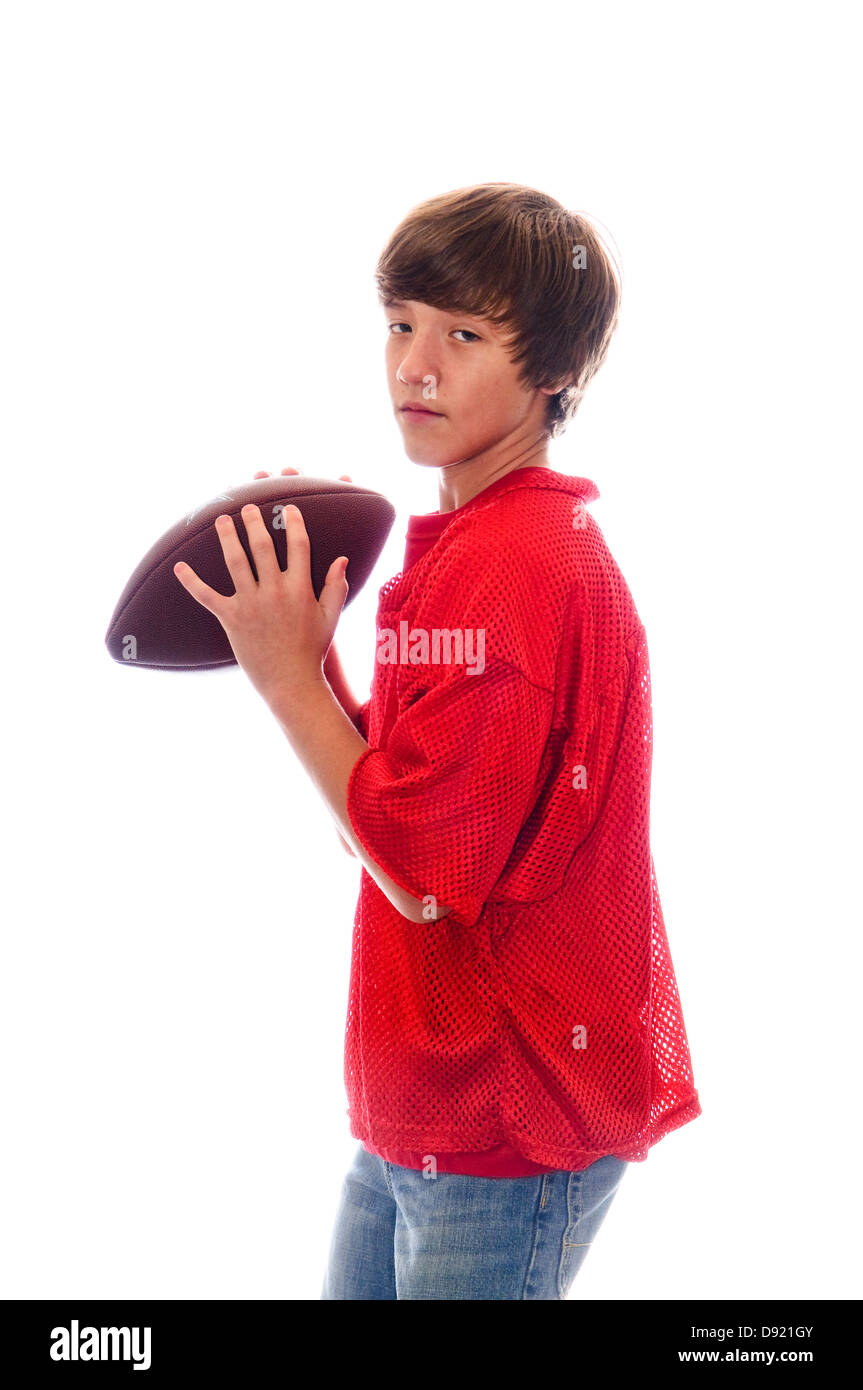 Jeune adolescente quarterback holding a football isolé sur blanc. Banque D'Images