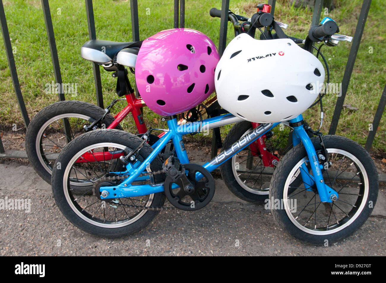 Hyde Park deux vélos pour enfants, un rose, un bleu, avec des casques Banque D'Images