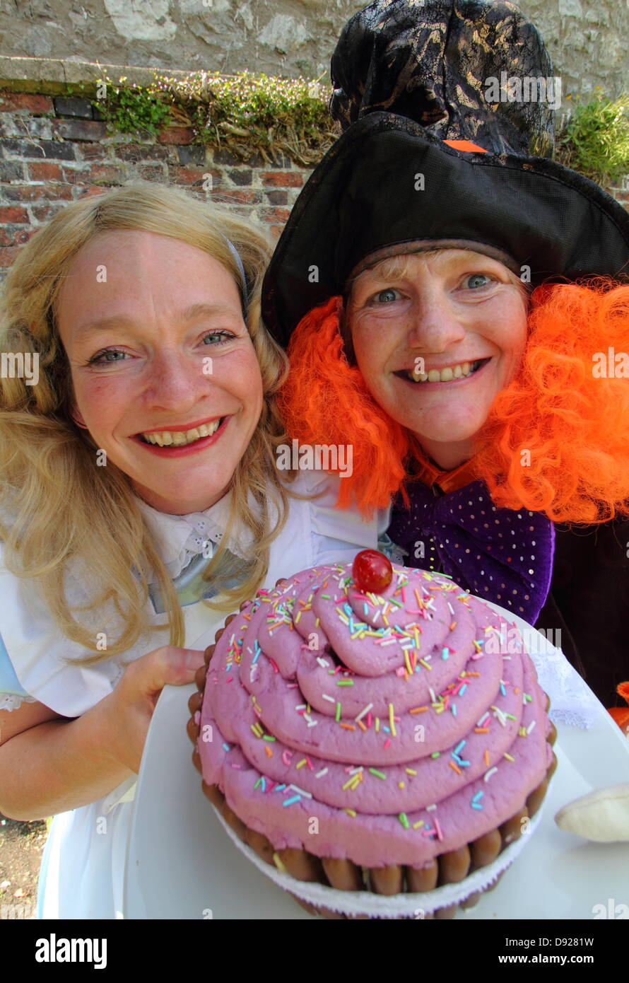 Bakewell, Derbyshire, Royaume-Uni. 9 juin 2013. Cuisson Bakewell Festival. Anni Tosh (Alice), et Alison Benefield (Mad Hatter), Histoire de la compagnie de théâtre du sac pour un grand plateau de fossé cup-cake, Thé du Chapelier fou. Credit : Deborah Vernon/Alamy Live News Banque D'Images