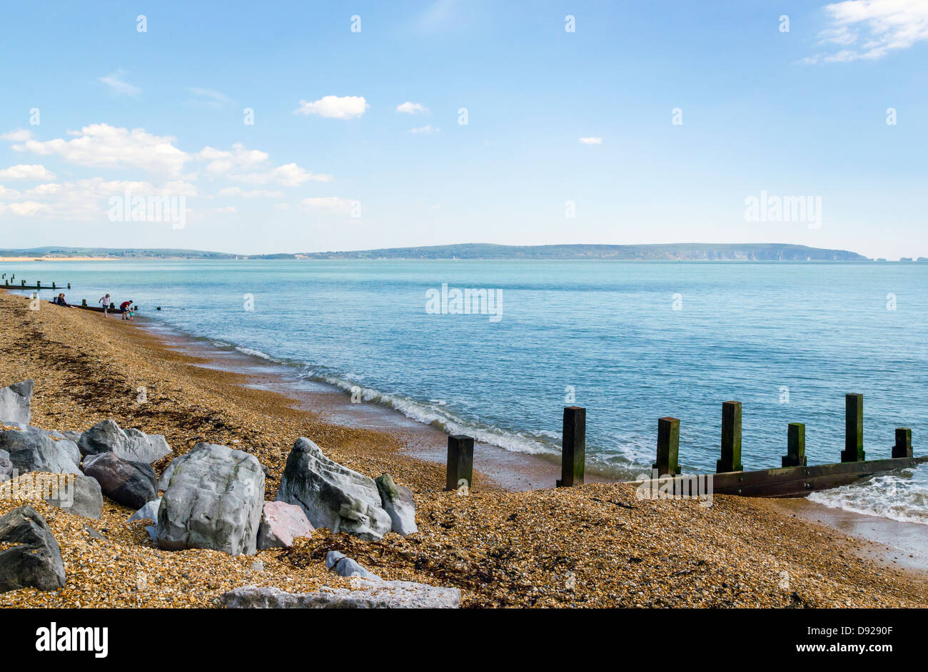 Plage de galets et des éperons rocheux près de Milford-On-mer donnant sur le Solent et l'île de Wight avec les gens sur plage à distance Banque D'Images