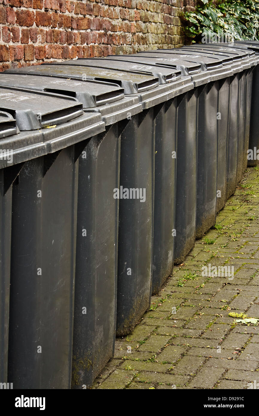 Rangée de gray wheelie les bacs utilisés pour le stockage des déchets ou de l'élimination des déchets ménagers Banque D'Images