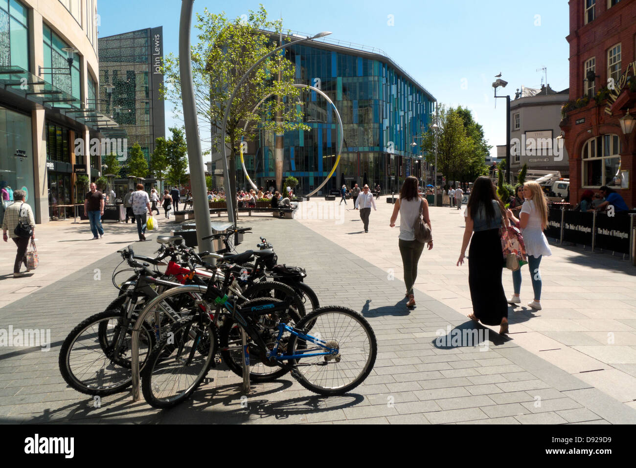 Vélos garés personnes marchant dans la rue commerçante piétonne du centre-ville de Cardiff et magasin John Lewis Central Library Cardiff, pays de Galles, Royaume-Uni KATHY DEWITT Banque D'Images