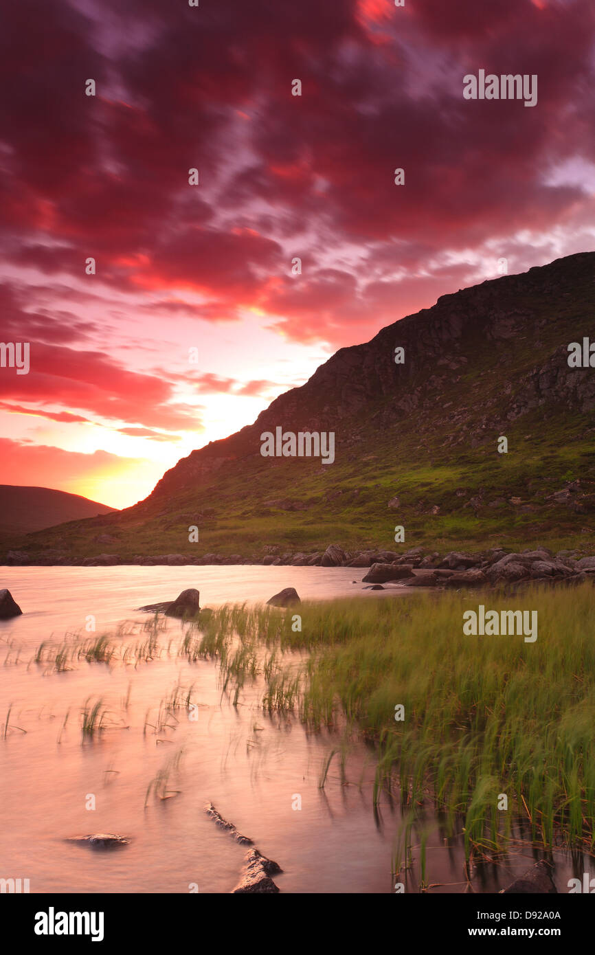 Ciel du soir colorés sur le lac Storevatn sur l'île de Runde, Herøy kommune, Møre og Romsdal fylke, la Norvège. Banque D'Images