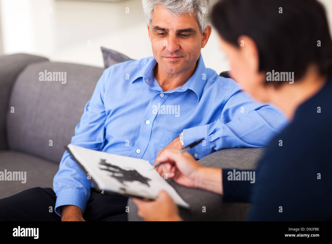 Homme d'âge moyen déprimé en session avec le thérapeute Banque D'Images
