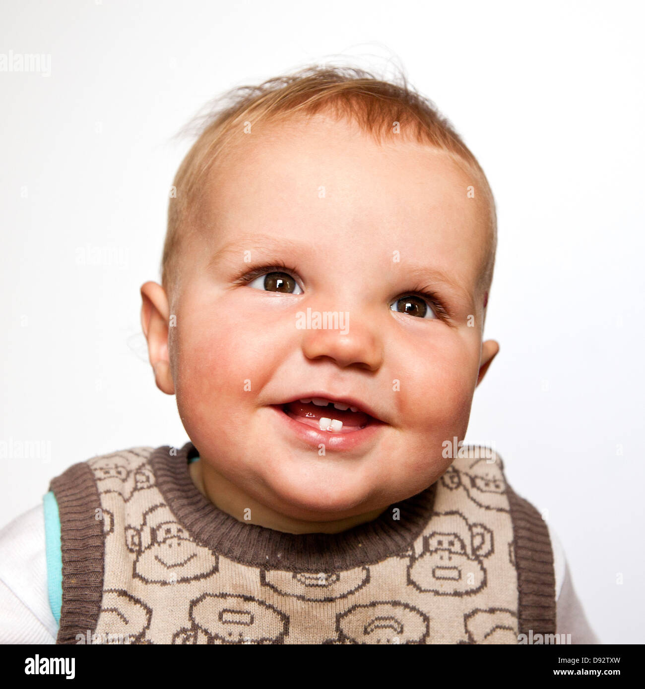 Un baby boy looking up heureusement, head and shoulders portrait Banque D'Images