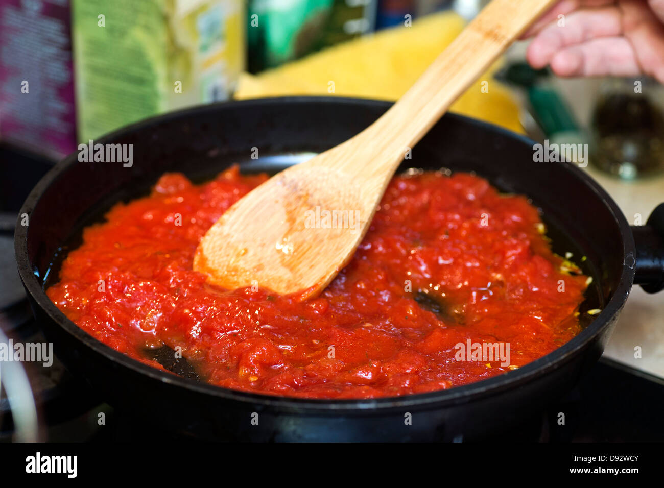 Sauce tomate dans poêle avec spatule en bois Banque D'Images