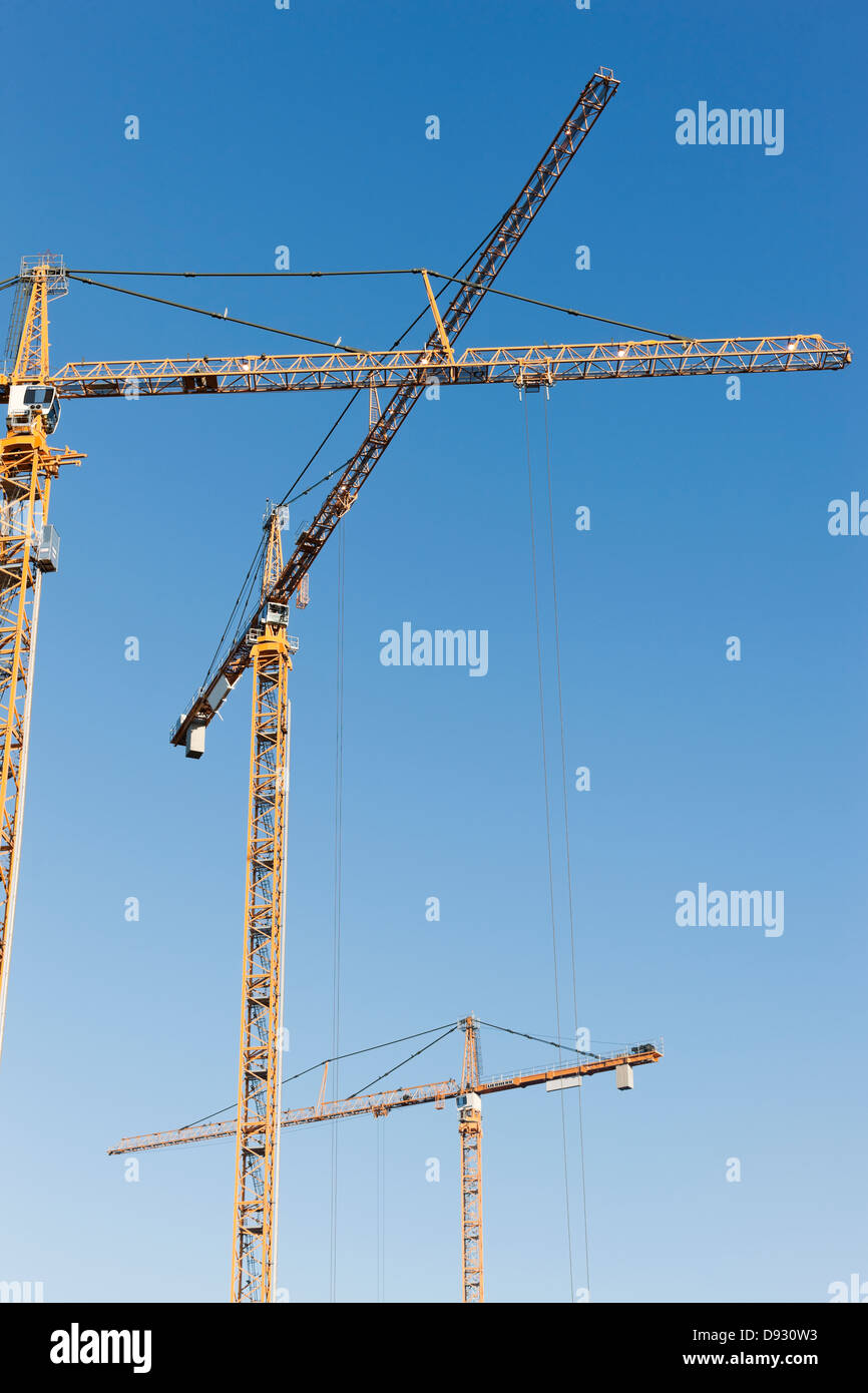 Grues de construction contre le ciel bleu Banque D'Images