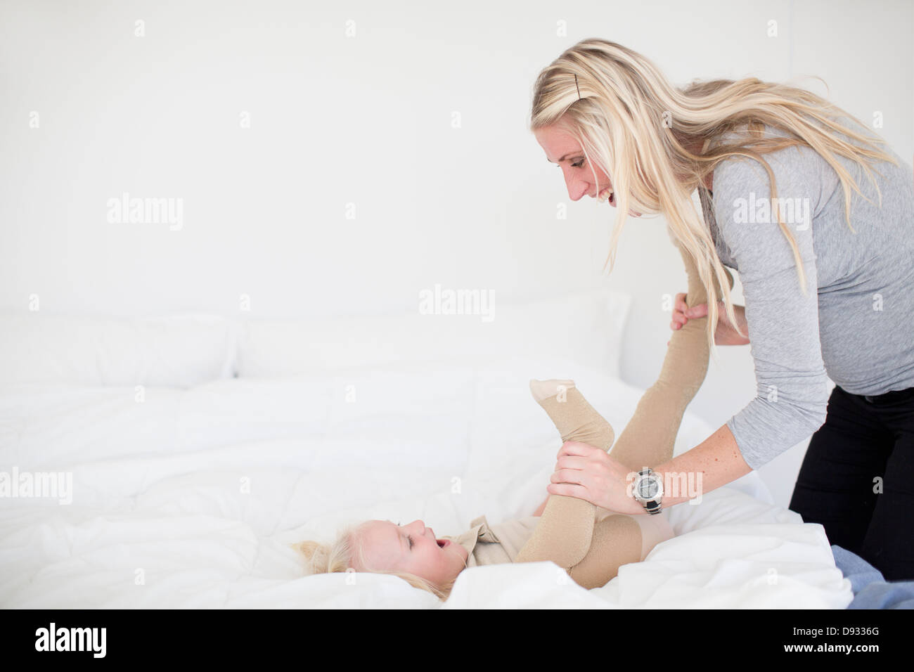 Mère jouant avec sa fille dans le lit Banque D'Images