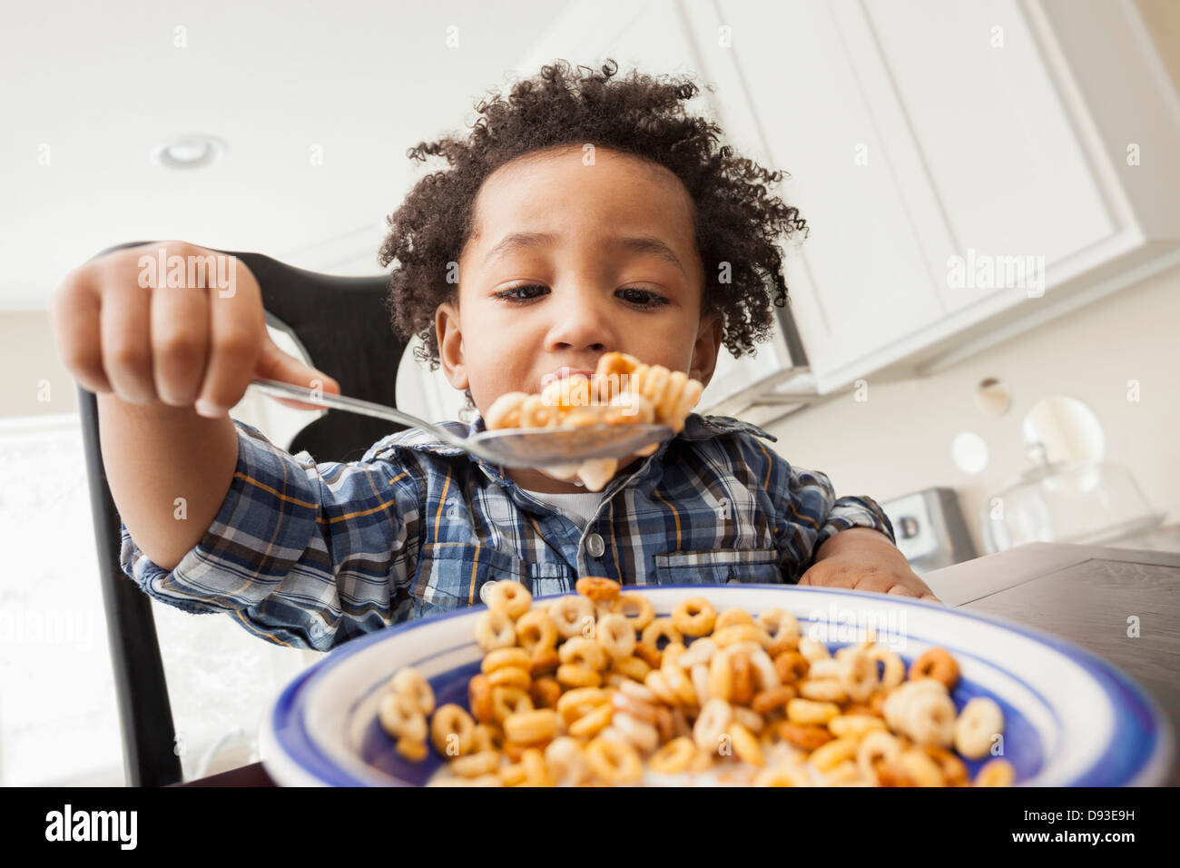 Mixed Race boy eating at table Banque D'Images