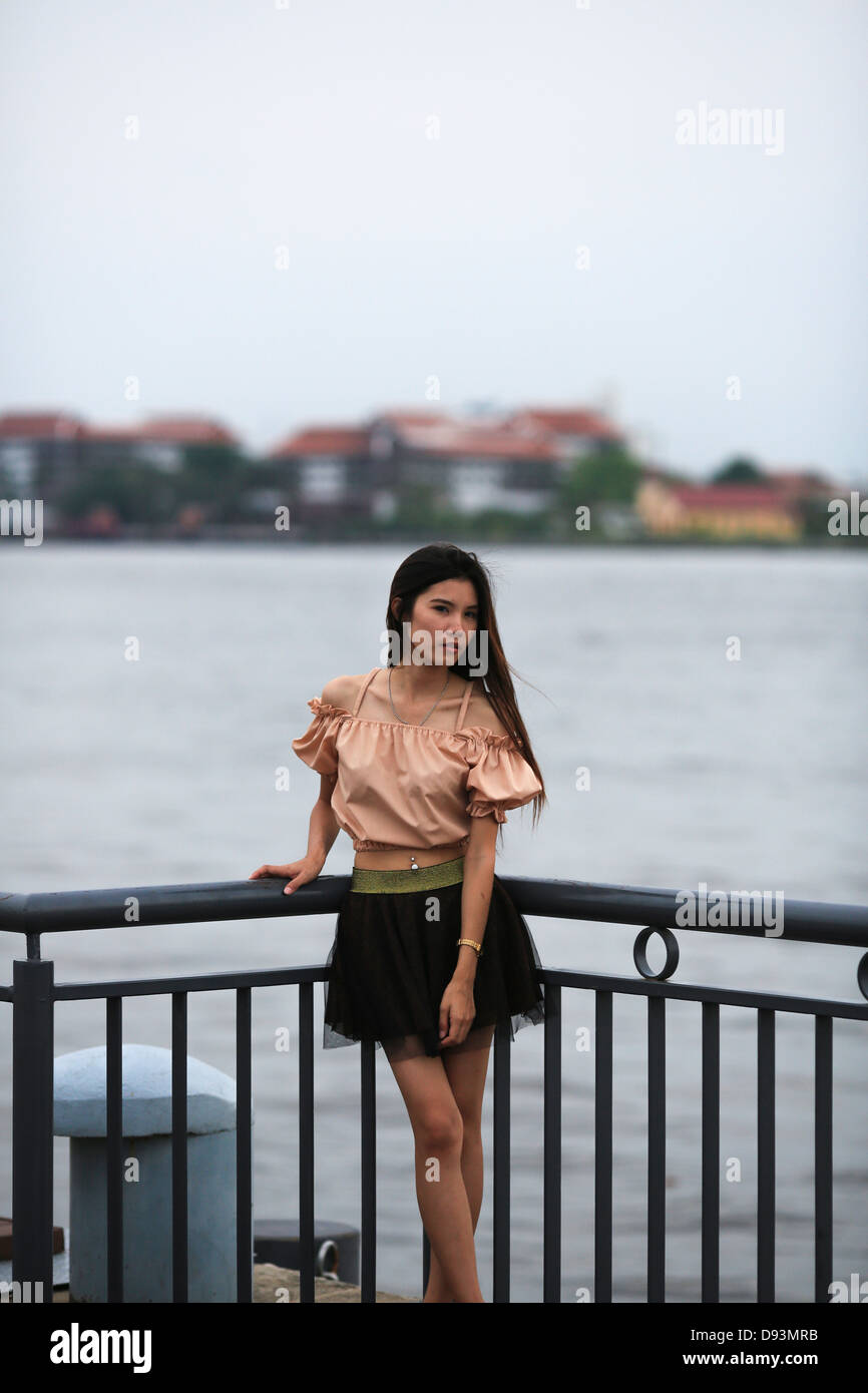 Thai Dame posant pour l'appareil photo en face de la rivière principale de Bangkok, le Chao Praya Banque D'Images