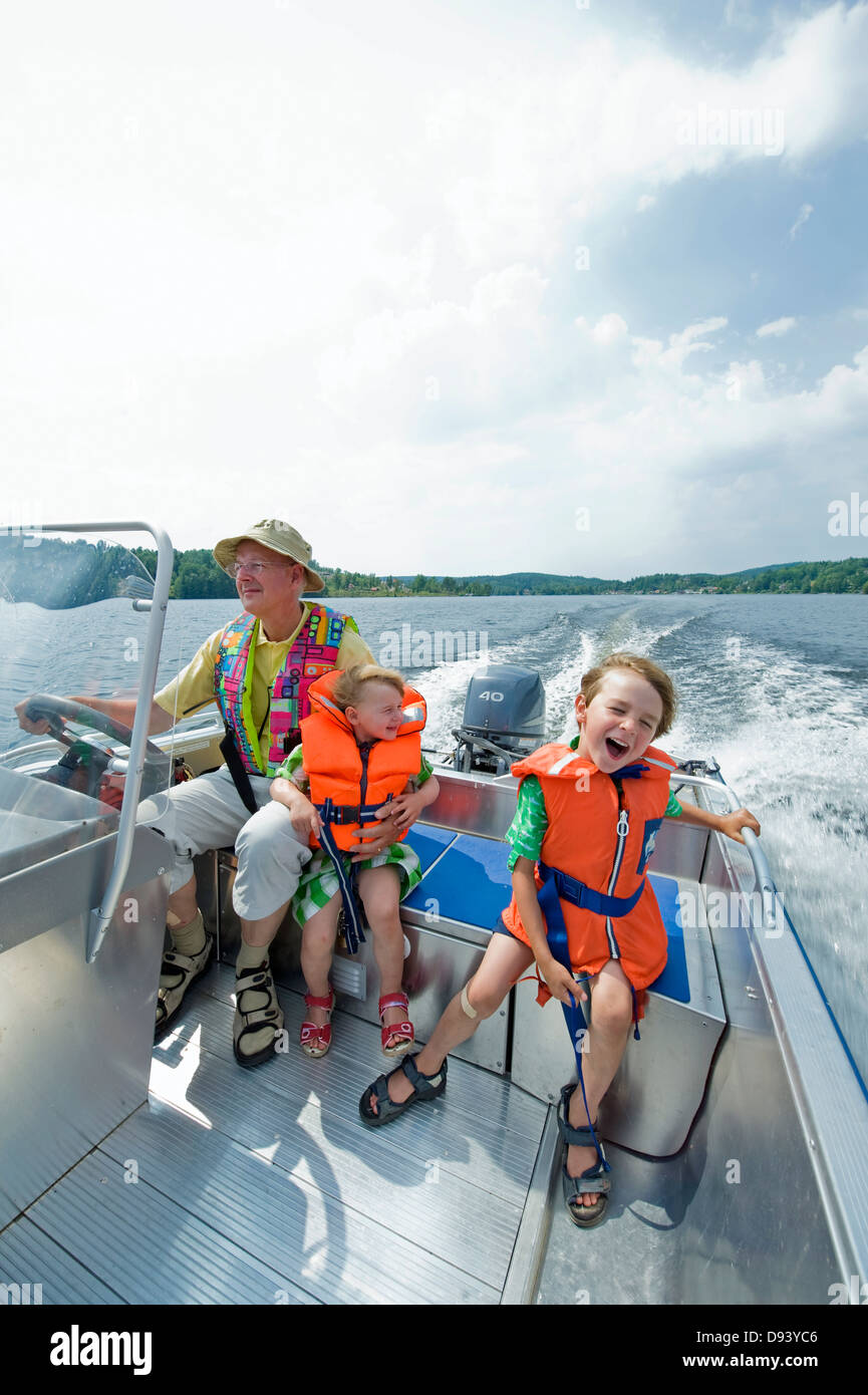 Grand-père le bateau à moteur avec garçon et fille Banque D'Images