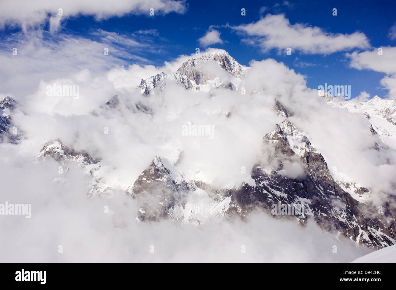 Sommets enneigés derrière les nuages Banque D'Images