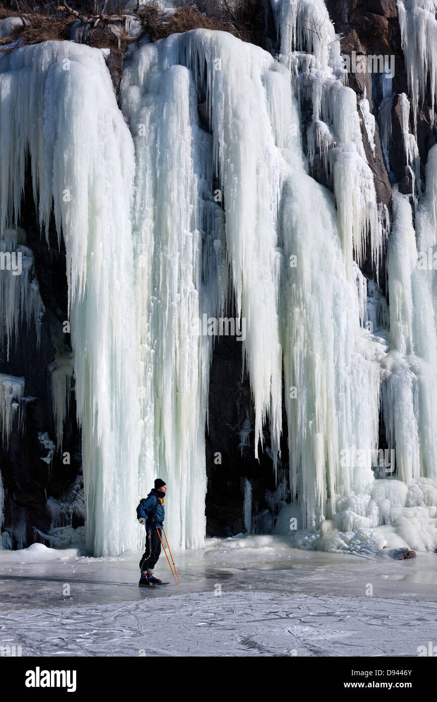 Homme debout en face de cascade de glace Banque D'Images