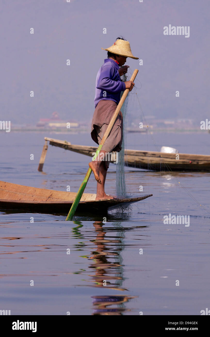 Un pêcheur du lac Inle portant l 'traditionnels' Longyi (alias Longhi) partie d'un groupe de 'traditionnels' rameurs jambe en Birmanie Banque D'Images