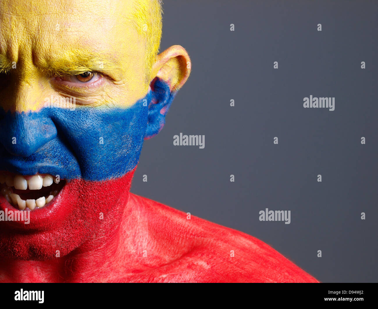 Face à l'homme peint avec drapeau colombien. L'homme est en colère et composition photographique ne laisse que la moitié de la face. Banque D'Images