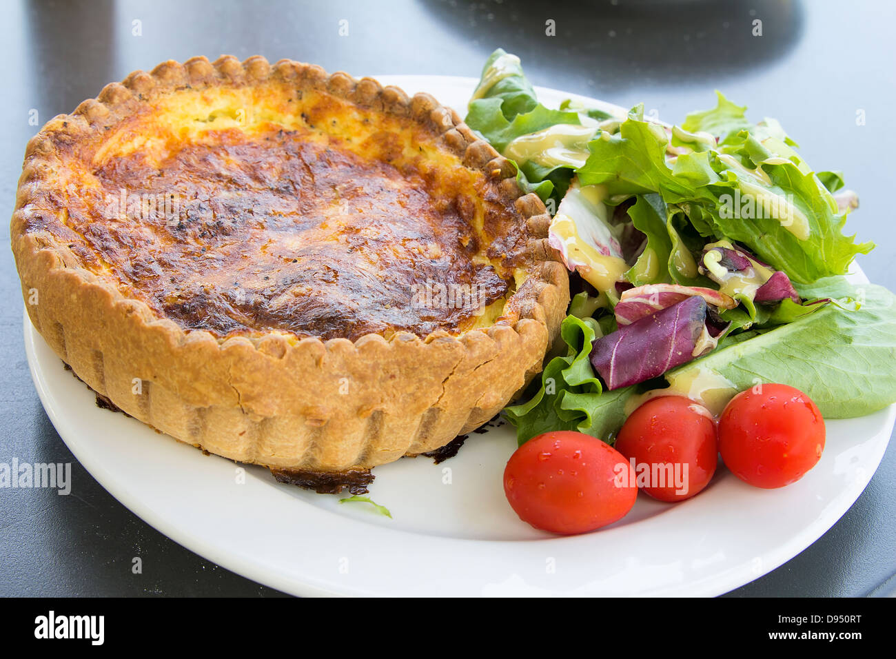 La quiche lorraine pâte avec un mélange de salade verte et tomates Banque D'Images