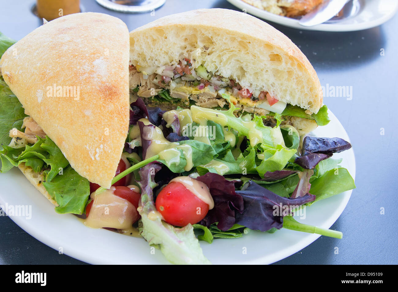 Sandwich à la salade de thon et légumes pain ciabatta Salade verte avec des tomates Banque D'Images