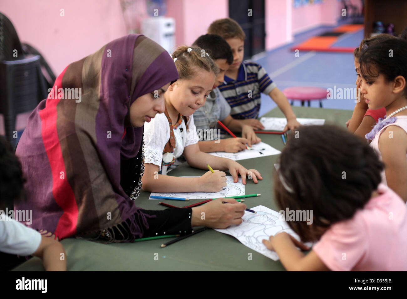 11 juin 2013 - La ville de Gaza, bande de Gaza, territoire palestinien - enfants palestiniens tirer tableaux à un centre de divertissement pendant les vacances d'été dans la ville de Gaza le 11 juin 2013. Et les établissements de divertissement dans la bande de Gaza l'accent sur diverses activités pour les enfants pendant les vacances qui incluent des jeux, l'écriture créative, des compétitions, des projections de films, la narration et le dessin libre (crédit Image : © Ashraf Amra/APA Images/ZUMAPRESS.com) Banque D'Images