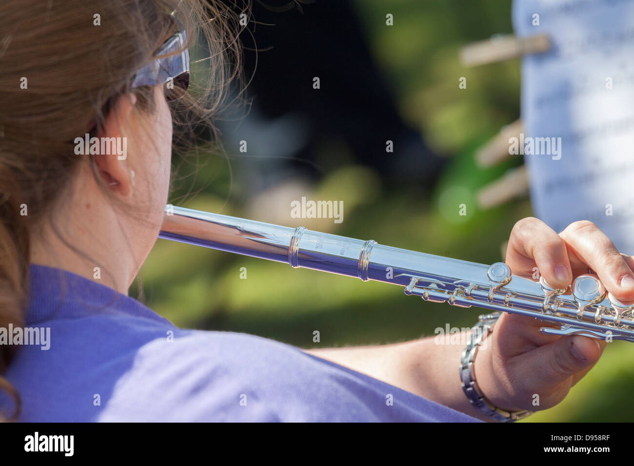 Llooking sur épaule de femme jouant de la flûte. Banque D'Images