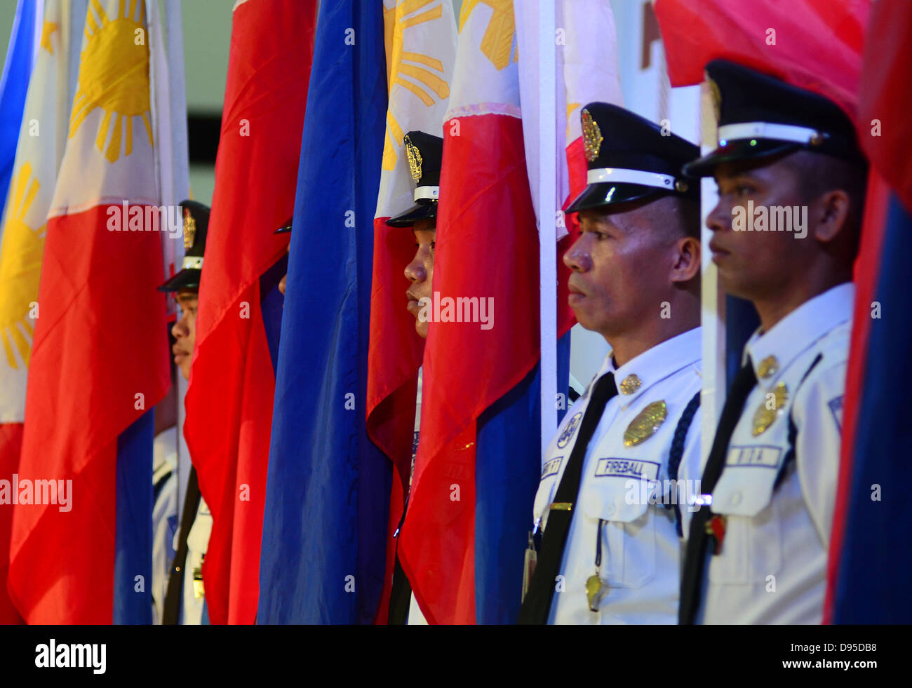 La ville de Davao, Philippines du Sud. 12 Juin, 2013. Les agents de sécurité philippins sur la photo comme ils portent des drapeaux nationaux des Philippines pour marquer le 115e anniversaire de l'indépendance des Philippines dans un centre commercial dans la ville de Davao, Philippines du Sud, 12 juin 2013. Un défilé de 115 drapeaux des Philippines Philippines portés par des gardiens de sécurité dans un centre commercial fait partie de la 115e fête de l'indépendance des Philippines. Banque D'Images