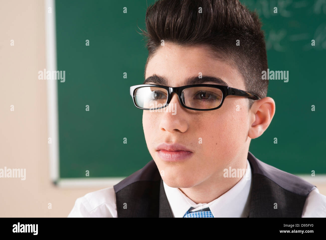 Close-up Portrait of boy in front of Chalkboard in Classroom Banque D'Images