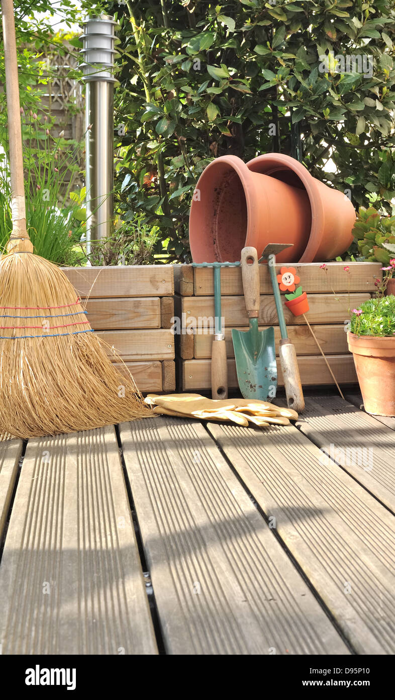 Différents accessoires de jardinage et de nettoyage sur une terrasse en bois Banque D'Images