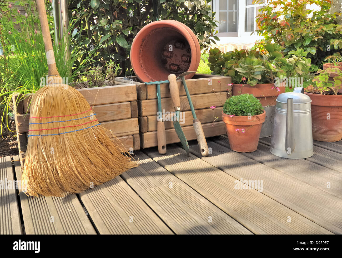 Différents accessoires de jardinage et de nettoyage sur une terrasse en bois Banque D'Images