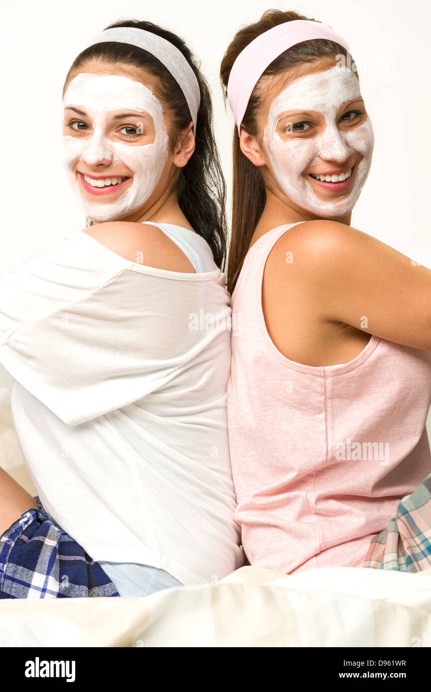 Deux amis assis dos à dos avec masque facial blanc Banque D'Images