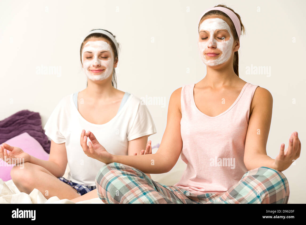 Les femmes méditant assis en tailleur portant masque blanc Banque D'Images
