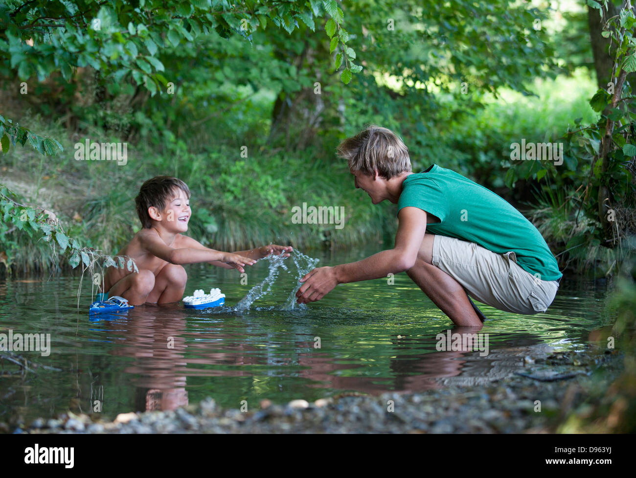 L'Autriche, les amis à jouer avec voile dans le ruisseau, smiling Banque D'Images