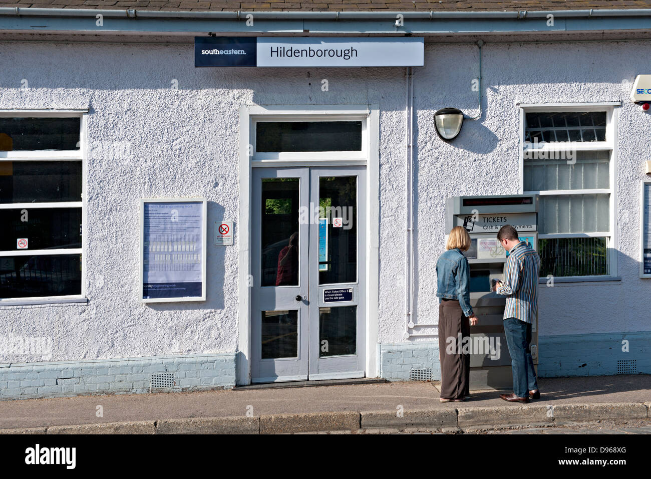 Un jeune couple à l'aide de la machine de billets à la gare de Hildenborough, UK Banque D'Images