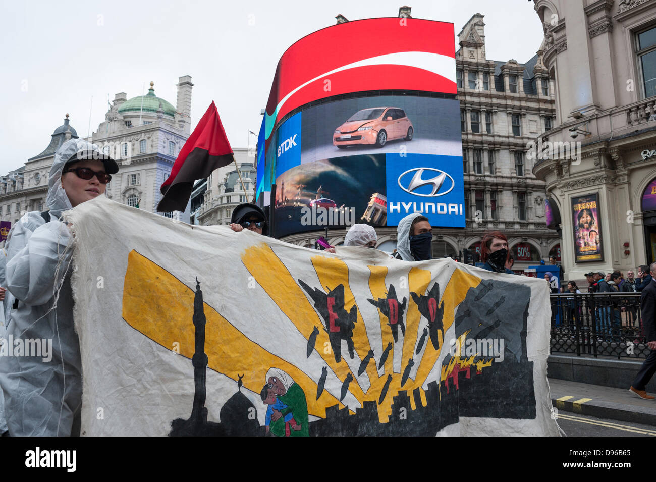 Londres, Royaume-Uni, 12 juin 2013. Sussex Arrêter G8, Smash EDO et désarmer le DEES collectivement ont uni leurs forces pour prendre un tour à travers whistle stop l'extrémité ouest de Londres pour mettre en lumière des préoccupations des entreprises liées à la fabrication et la vente d'armes militaires basées au Royaume-Uni. Le lieu de rencontre a eu lieu en dehors de l'immeuble de BAE Systems, Carlton Gardens, la démonstration d'être accompagnée d'une forte présence de la Police métropolitaine. Credit : Lee Thomas/Alamy Live News Banque D'Images