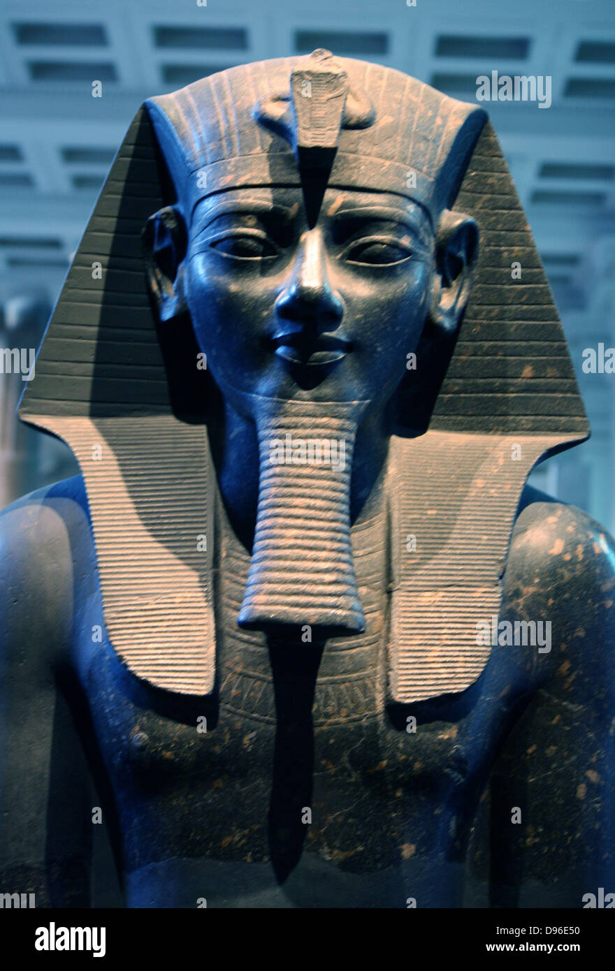 Statue du Roi Amenhotep III. 18e dynastie, vers 1400 av. J.-C. le roi de Thèbes est représenté en robe et pose classique. Assis sur un trône avec les deux mains à plat sur les genoux, elle porte un nemes-headcloth, fausse barbe et kilt court, qui équipé d'une cérémonie de la queue de taureau, indiqué entre la jambe. Les noms du roi sont inscrits sur la face avant et arrière du trône et de la courroie de la kilt. Banque D'Images
