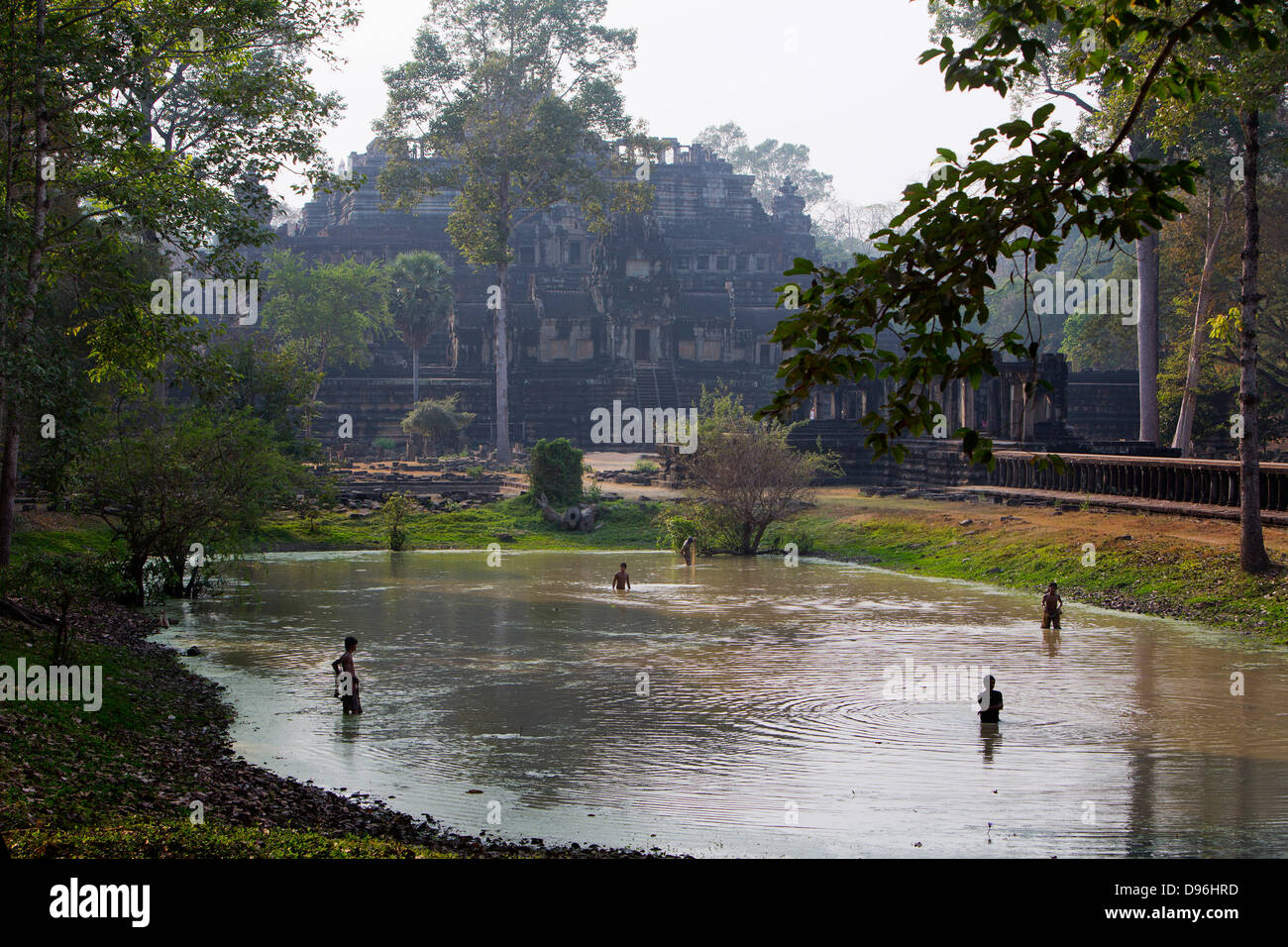 Pêche Les garçons dans le lac par le Temple Baphuon, Angkor Thom, au Cambodge Banque D'Images