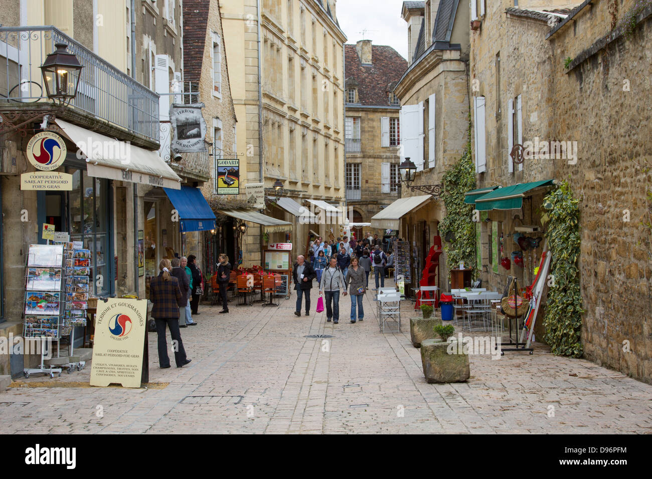 Les touristes flâner parmi les boutiques logées dans des bâtiments de grès médiévale dans la charmante ville de Sarlat, Dordogne France Banque D'Images