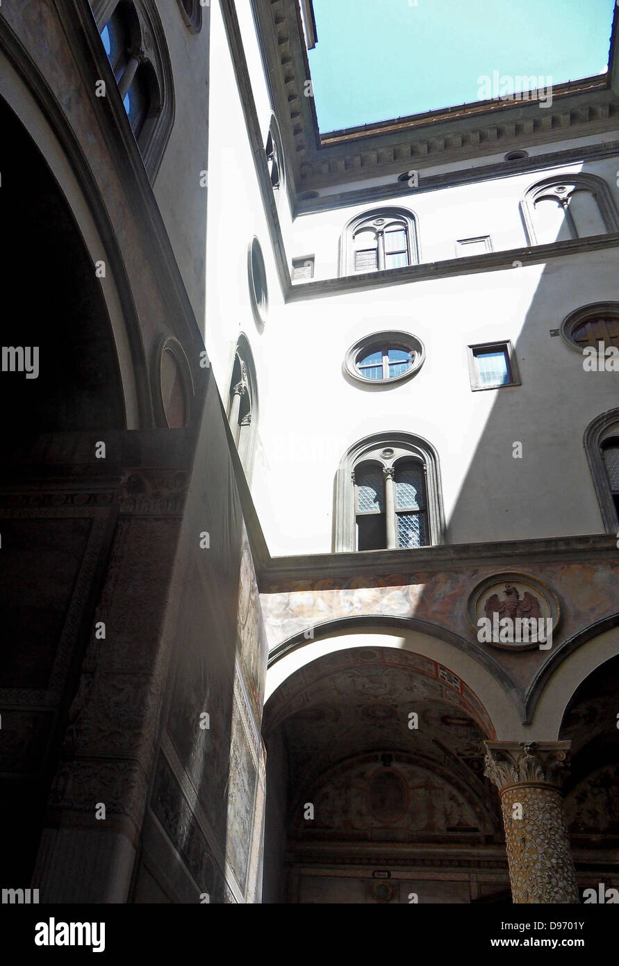 Le Palazzo Vecchio, Florence, Italie. Ce massif, d'époque romane. La première cour a été conçu en 1453 par Michelozzo. Dans les lunettes, haute autour de la cour, sont des crêtes de l'Église et les guildes de la ville. Au centre, la fontaine de porphyre est par Battista del Tadda. Banque D'Images