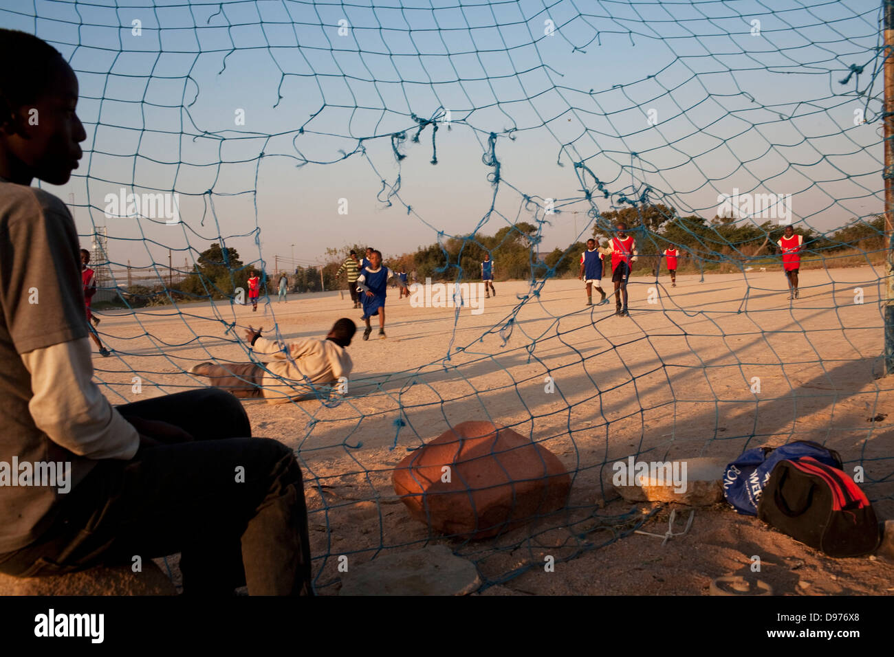 <p >les enfants jouer au football football local en regard de vieille glace-crème en usine Alexandra Township Johannesburg. </p > Banque D'Images