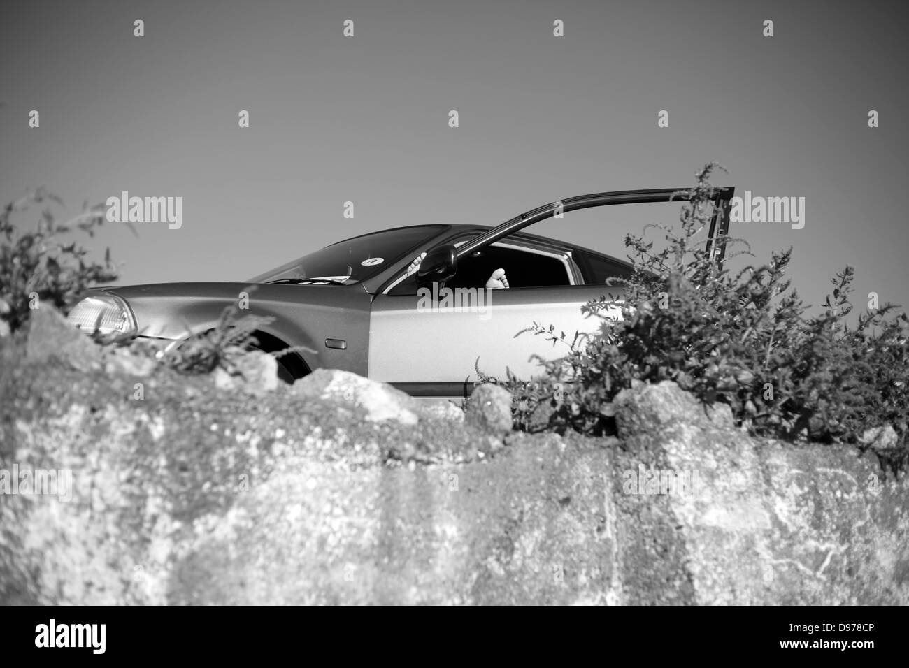 Un soleil mans orteils pop sur la fenêtre d'une voiture. Banque D'Images