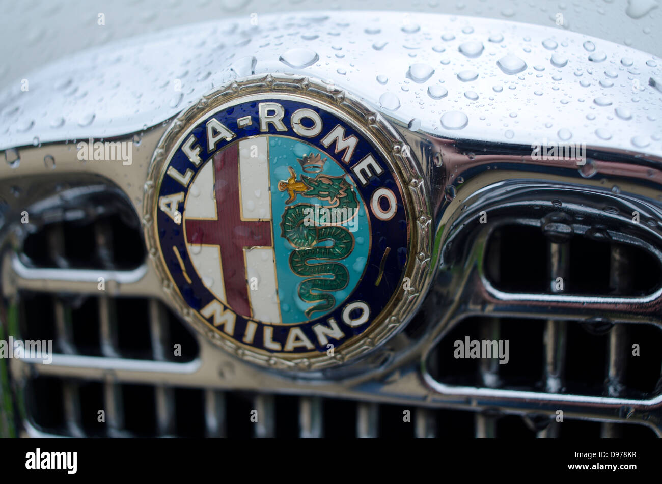 Le logo et l'emblème d'Alfa Romeo sur la grille d'une vieille voiture de l'entreprise avec des gouttes de pluie Banque D'Images